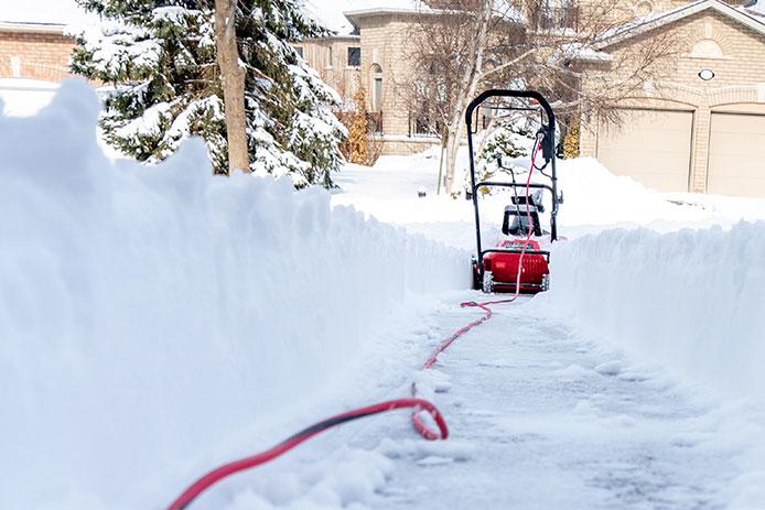 Electric snowblower in distance with extension cord