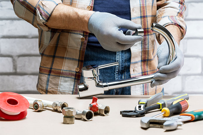 Plumber repairing a faucet for a sink at house or office.