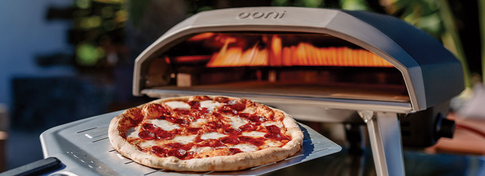 Cooking pizza in a silver Ooni pizza oven